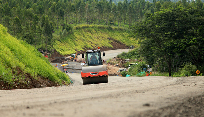 Foto de una maquina aplanadora vibrocompactando el suelo de una carretera en construcción