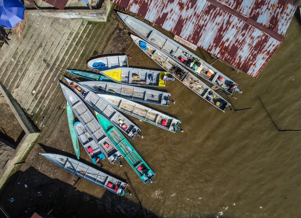 Fotografia de plano cenital tomada con un dron en la que se ven varias embarcaciones a orillas del río Guapi, en Guapi