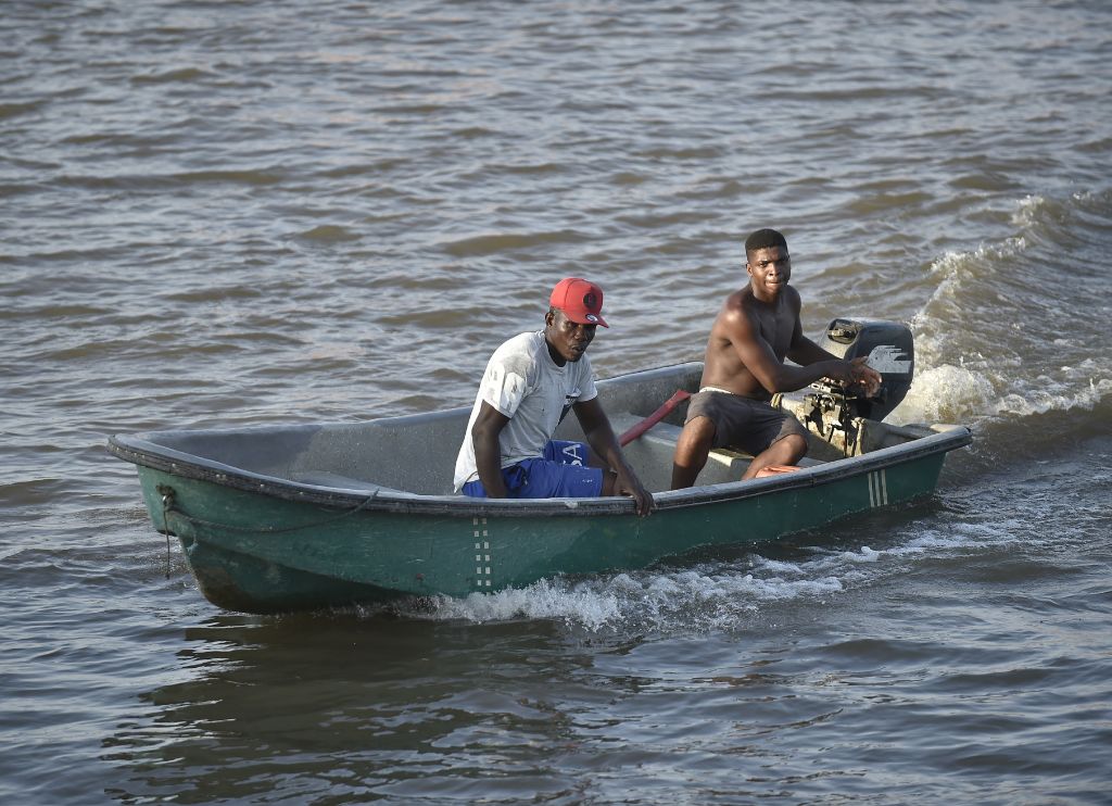 Dos hombres navegan a bordo de una embarcación a motor en el río Guapi, Cauca